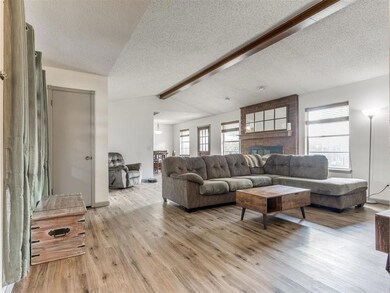 Living room featuring a textured ceiling, wood finished floors, and a fireplace