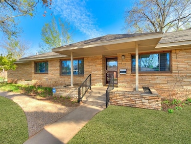 View of front of house featuring a front lawn, covered porch, and roof with shingles