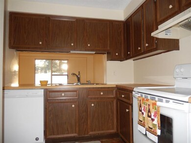 Open to the dining room the kitchen features a new dishwasher and disposal.  There's a stainless steel double bowl sink with updated faucet with soap dispenser and updated vinyl tile flooring.