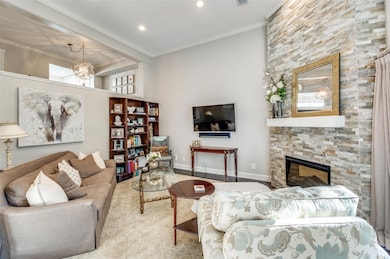 Living room with a fireplace, crown molding, and a
