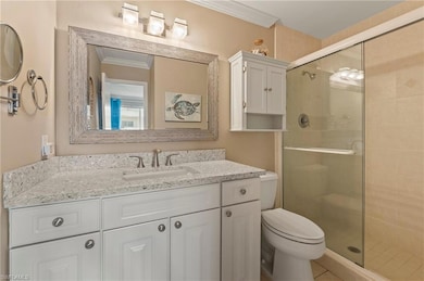 Full bath with a shower stall, crown molding, and vanity