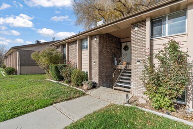 View of exterior entry with brick siding and a yard