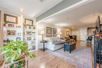 Living room featuring wood finished floors, baseboards, visible vents, recessed lighting, and crown molding