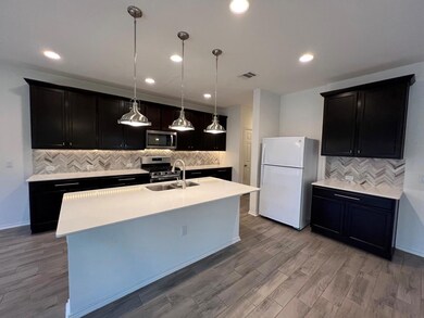 Kitchen with dark cabinets, hanging light fixture