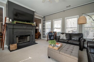 Living room with ceiling fan, light colored carpet