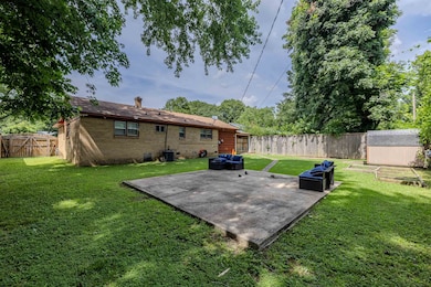 Fenced backyard with a patio area and a shed