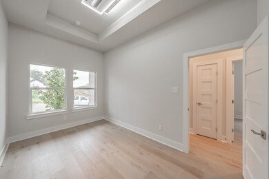 Unfurnished room with cooling unit, a raised ceiling, and light wood finished floors