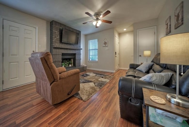 Living room featuring a brick fireplace, wood fin