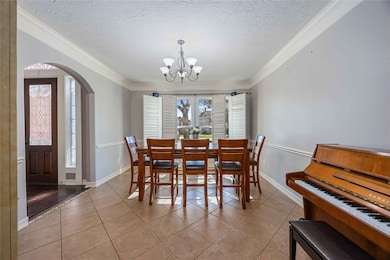 “Bright and inviting formal dining room featuring elegant tile floors, crown molding, and charming plantation shutters.”