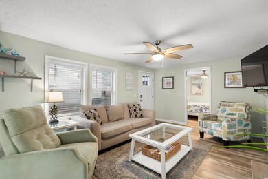Living room featuring ceiling fan, wood finished floors, and a textured ceiling