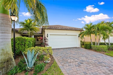 Mediterranean home featuring stucco siding, decorative driveway, a garage, and a tiled roof