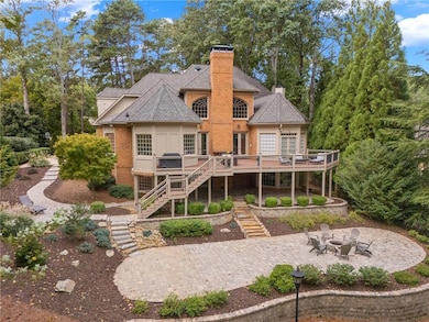 Rear view of house featuring stairway, a chimney, a patio area, a deck, and a fire pit
