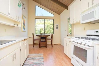 Kitchen with high windows and views of lush vegeta