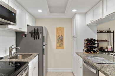Kitchen featuring a tray ceiling, white cabinetry,