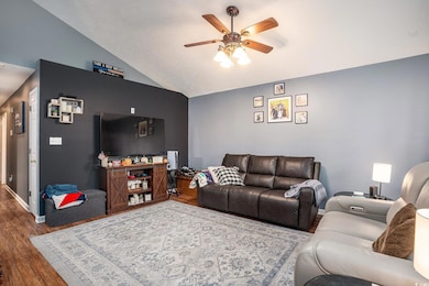 Living area featuring vaulted ceiling, wood finished floors, and ceiling fan