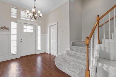 Foyer entrance featuring an inviting chandelier, h