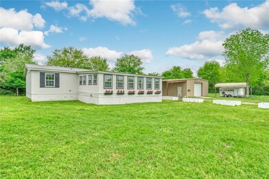 View of front of home with a front yard, an outdoo