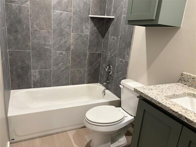 Full bathroom featuring vanity, tub / shower combination, wood finished floors, and toilet