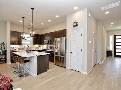 Kitchen with stainless steel appliances, dark bro