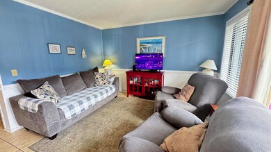 Living room with tile patterned floors, crown mold