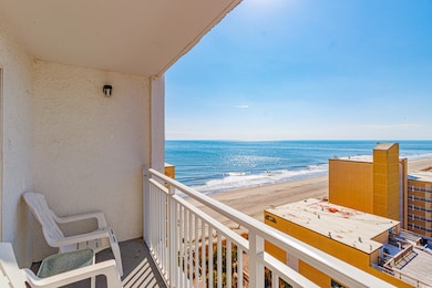 Balcony featuring a water view and a beach view
