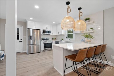 Kitchen offers extended counter for bar stools and stainless steel appliances.