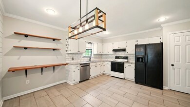 Kitchen featuring black refrigerator, electric ran