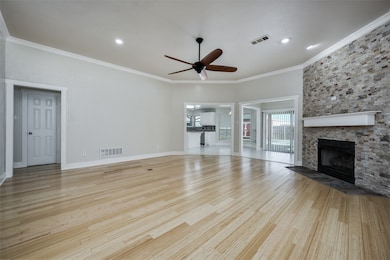 Unfurnished living room featuring ornamental molding, ceiling fan, light wood-type flooring, a fireplace, and recessed lighting
