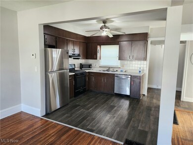 Kitchen featuring  appliances, ceiling fan, dark brown cabinetry, tasteful backsplash, and dark luxury vinyl floors