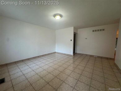 Empty room featuring baseboards and light tile patterned floors
