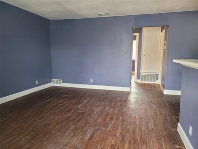 Spare room with baseboards, visible vents, and wo