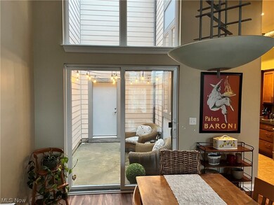Dining area featuring dark hardwood / wood-style flooring, a healthy amount of sunlight, a towering ceiling, and a chandelier