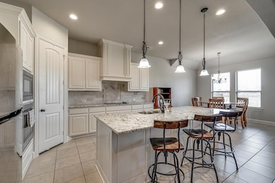 Kitchen featuring a sink, white cabinets, light st