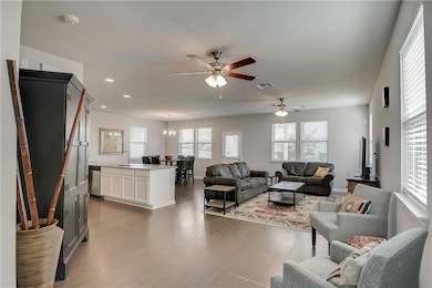 Living area with a ceiling fan, wood finished flo