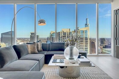 Living room with a city view, healthy amount of natural light, a wall of windows, and wood finished floors