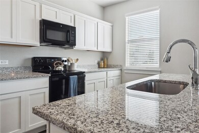 Kitchen with black appliances, a sink, healthy am