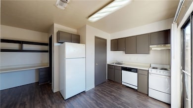 Kitchen featuring under cabinet range hood, white