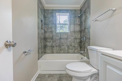 Full bathroom featuring a textured ceiling, tiled 
