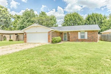 Single story home with brick siding, an attached garage, and driveway