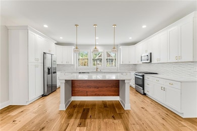Prepare to WOW your guests with an entertainer's kitchen that you would find in homes twice the price! This custom kitchen showcases quartz counters, stainless appliances, an enormous quartz island & an abundance of storage! This kitchen overlooks th