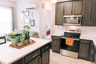 Kitchen with stainless steel appliances, a wall m