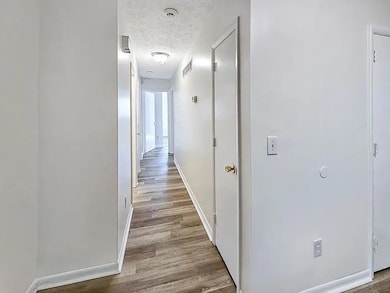 Unfurnished room with light wood-style floors and a textured ceiling