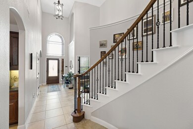 Entryway featuring a towering ceiling, arched wal