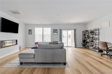 Living area featuring baseboards, visible vents, a