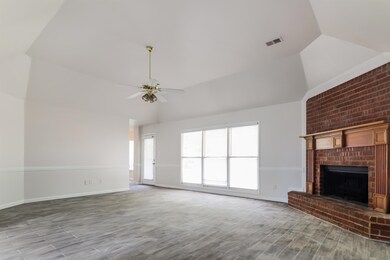 Unfurnished living room featuring ceiling fan, bri
