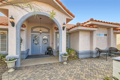 Entrance to property with a tile roof and stucco s