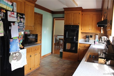 Kitchen featuring black appliances, stone finish f