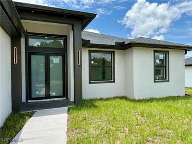 Doorway to property with stucco siding, a yard, fr