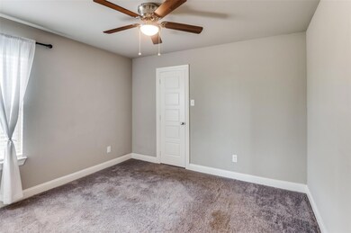 Carpeted empty room featuring ceiling fan