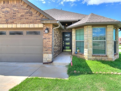 Entrance to property with a garage, brick siding, concrete driveway, and a shingled roof
